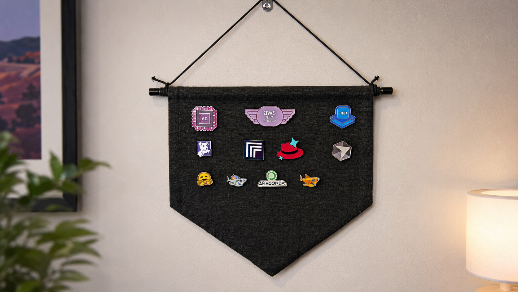 Black hanging fabric banner displaying a curated collection of colorful tech conference enamel pins like trophies from past events.
